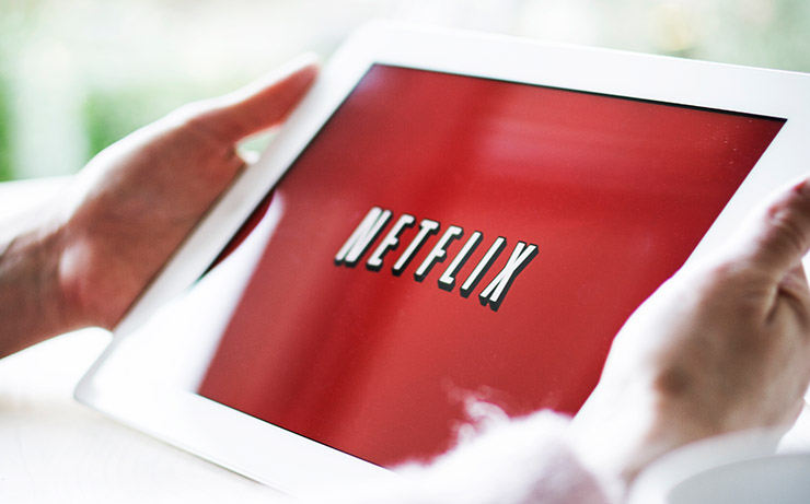 Hands Holding White Tablet with Netflix