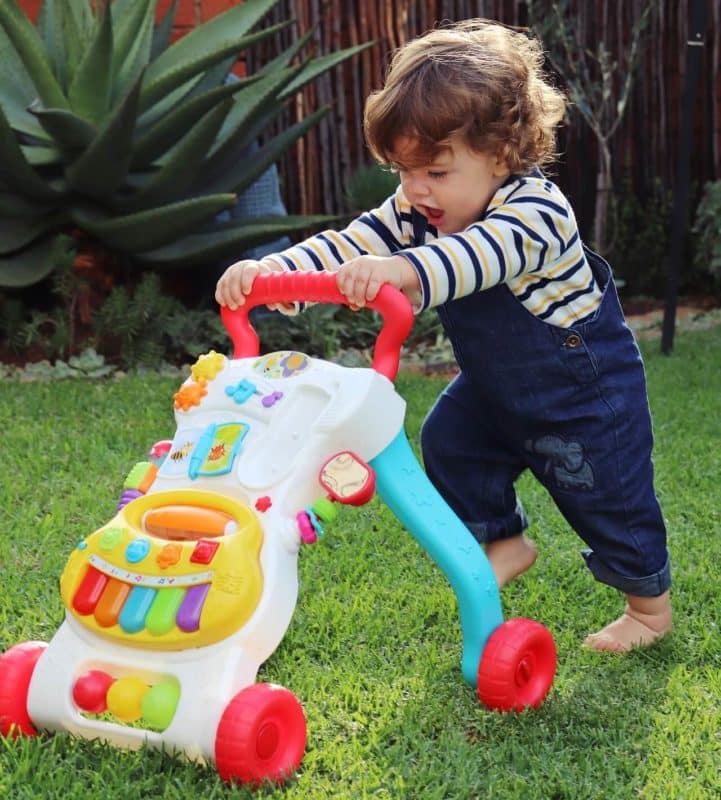 baby pushing walker outside